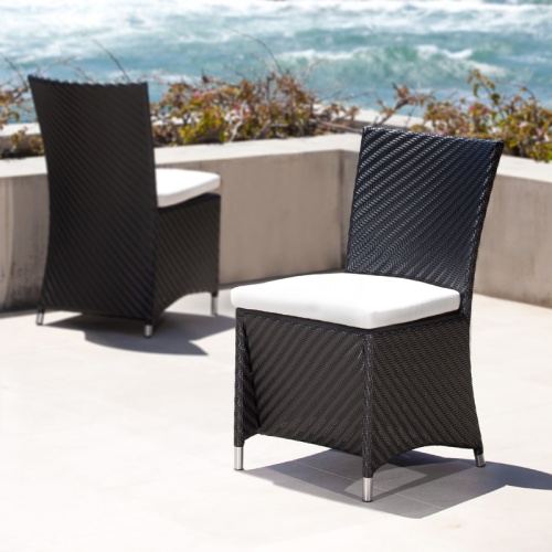 29002BKDP  Valencia Black Side Chair with seat cushion showing 2 on a concrete terrace surrounded by landscape plants with ocean and blue sky background 