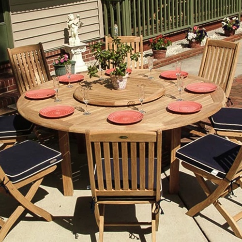 70026 Buckingham Barbuda teak 9 piece Dining Set of teak 72 inch round dining table and 8 teak side chairs with optional Lazy Susan in center and 8 plates and 8 glasses on patio