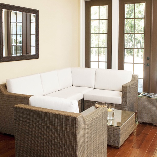 70242 malaga seven piece woven wicker set inside location on wood floors wall mirror  bowl mixed nuts floating candle magazines on glass top tables windows of outside patio
