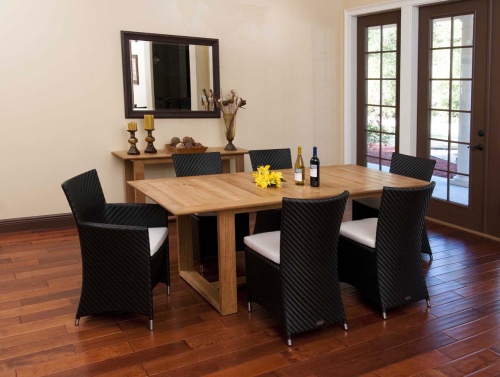 70243 Valencia 7 piece Dining Set with 2 wine bottles and yellow flowers on table center on wood floors indoors wall mirror side table with 2 pillar candles vase of dried flowers on back wall