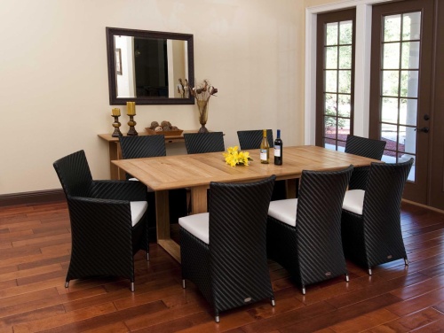 70248 Valencia 9 piece Dining Set with 2 wine bottles and yellow flowers on table center on wood floors indoors wall mirror side table with 2 pillar candles vase of dried flowers on back wall