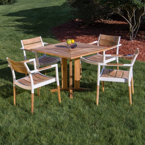 70452 Bloom Pyramid Bistro Dining Set of 4 Bloom teak and powder coated aluminum dining chairs and Pyramid 36 inch square teak dining table bowl of fruit on grass with trees in back 