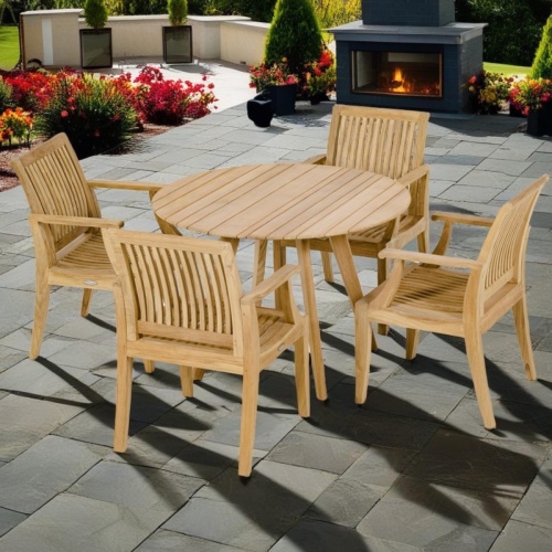 70544 Laguna & Surf 5 pc Dining Set of Surf Folding 42 inch Round Table and 4 Laguna Dining Armchairs in side view on a patio with outdoor fireplace in background