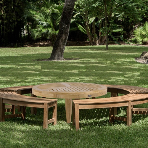 70863 Buckingham 5 piece teak backless bench and coffee table set on grass lawn with trees and green vegetation in background