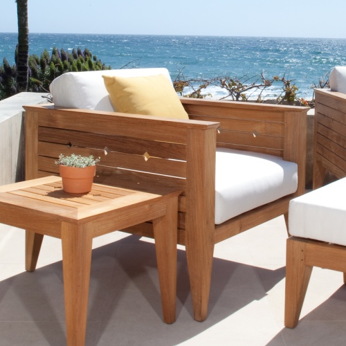 12160dp Craftsman teak armchair set cushions and throw pillow potted plant on end table outside on concrete terrace with flora and ocean background