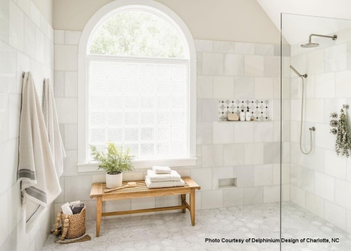 13068 Laguna teak 3 foot long Backless Bench with three folded towels back brush plant on top two hanging towels toiletries on niche in large walk in shower with white tile
