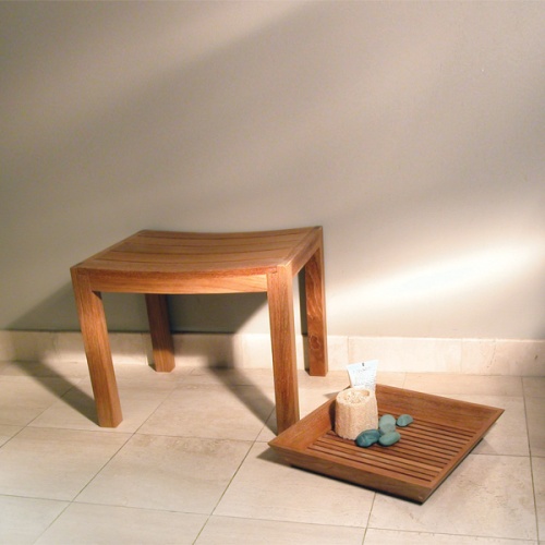 17420 Pacifica teak Vanity Tray with loofah black stones and lotion bottle on tiled indoor floor up against wall beside shower bench