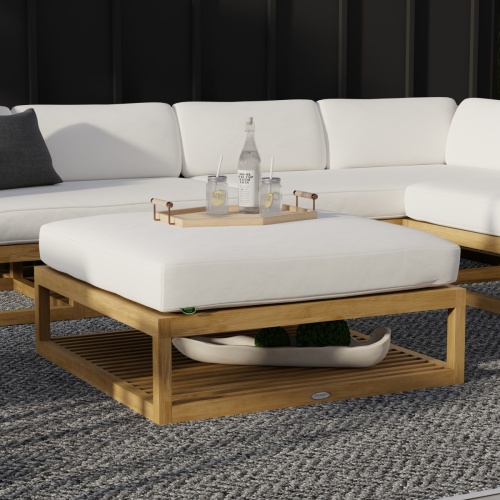 18800DP Maya Ottoman with cushion on outdoor patio with tray of 2 glasses and bottle water on ottoman in front of maya set with a house in the background