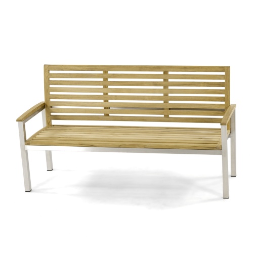 23200 Vogue 5 foot Teak and Stainless Steel Bench angled on concrete patio with shrubs and glass sliding doors in background