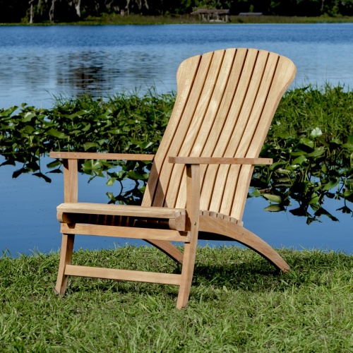 70000 Adirondack Chair and Footrest in angled side view on green grass with lake background