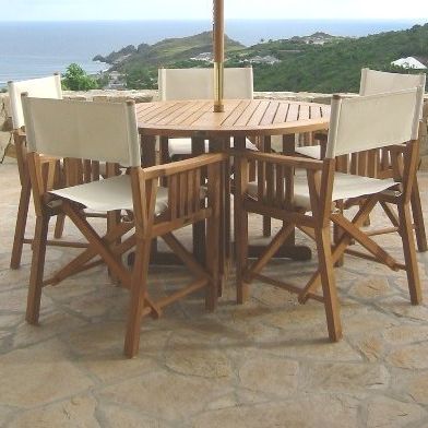 70001 Barbuda 5 piece teak Director Chair Set showing Barbuda Folding Table and 4 Director Chairs in angled side view with hillside and ocean background