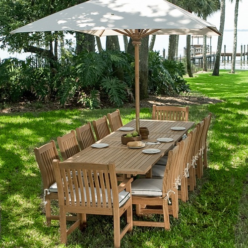 70017 Grand Veranda 13 piece dining set with optional seat cushions in angled side view on wood deck with water and trees in background 