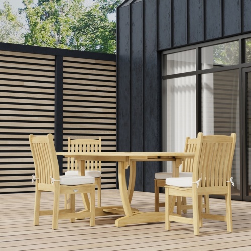 70031 Martinique Veranda 5 pc Dining Set of Martinique Oval Teak Table and 4 Veranda Side Chairs on wood deck with glass door and windows in background