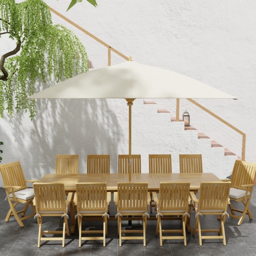 70095 Barbuda Teak 13 pc Patio Set with optional umbrella in side view next to a planter with a tree and a staircase in background