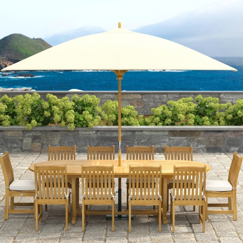 70166 Montserrat Veranda 11pc Dining Set with optional Umbrella and cushions on patio with pergola with hanging plants and vines and landscape plants in background