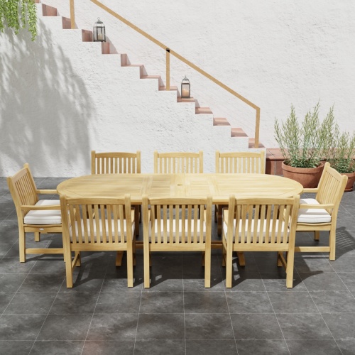 70178 Montserrat Veranda Teak 9 pc Dining Set side angled view on outdoor patio with potted plant and staircase of house and black archway in the background