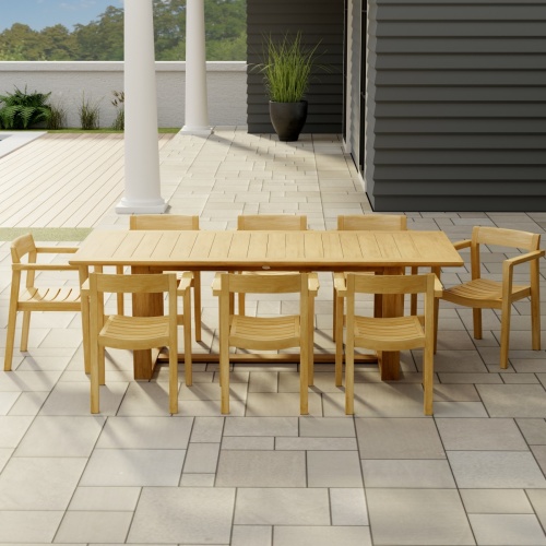 70220 Horizon 9 pc Teak Dining Set of Horizon Rectangular Extension Table and 8 Dining Armchairs in side angled aerial view on patio with 2 columns and pool in background