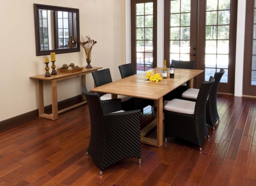70243 Valencia 7 piece Dining Set with 2 wine bottles and yellow flowers on table center on wood floors indoors wall mirror side table with 2 pillar candles end view facing french doors