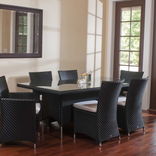 70260 Valencia wicker 7 piece dining set of 2 black armchairs 4 black side chairs and black rectangular dining table with floating candle on table indoors on wood floor with wall mirror 