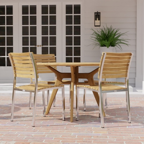 70825 Barbuda Surf 4 piece Dining Set of 4 folding side chairs and round 42 inch dining table in side view on brick paver patio and french door and potted fern in the background