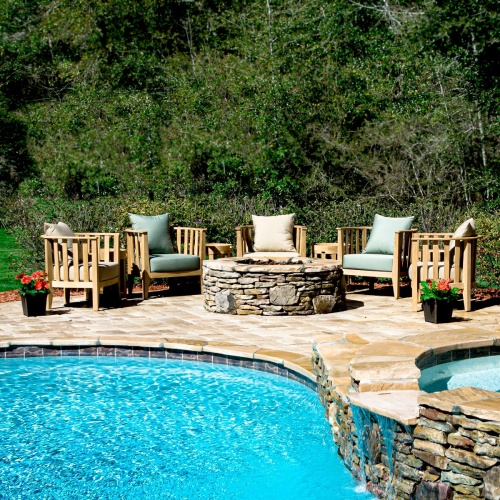 70421 Kafelonia 9 pc Fire Pit Seating Set showing 5 Kafelonia Club Chairs and 4 Side Chairs and Agora Fire Table in aerial view on outdoor patio with grass and ocean in the background  