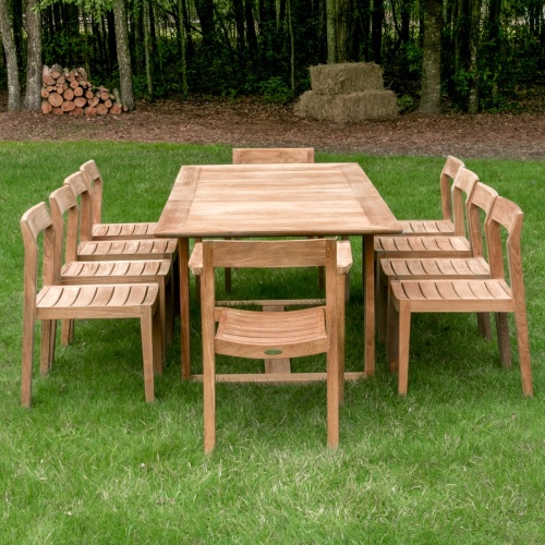 70457 Horizon 11 pc Teak Dining Set of Horizon Rectangular Teak DIning Table and 2 Teak Dining Armchairs and 8 Teak Side Chairs in side view on patio with ocean in background