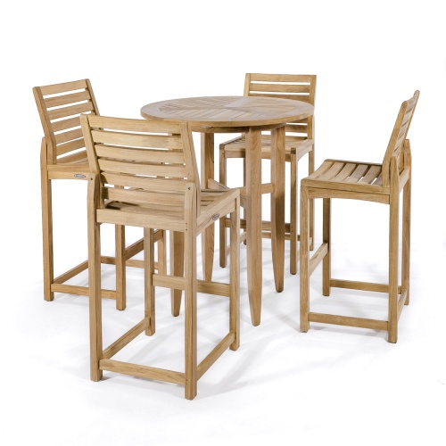 70532 Teak 5 piece Bar Table Set of 4 Somerset barstools and Laguna Table on tile patio against 2 window next to stack of chopped wood logs with house in background