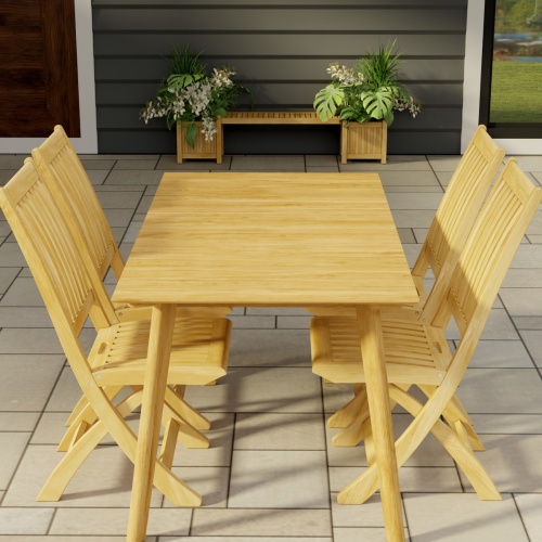 70562 Surf Barbuda Teak 5 pc Dining Set angled end view on tiled patio with 2 potted plants and a door and window of house in the background