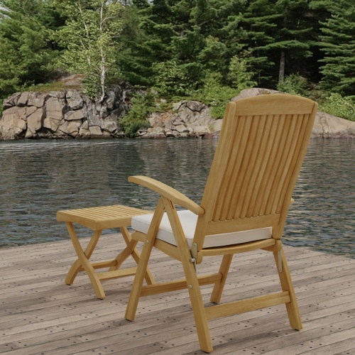 70706 Barbuda Teak Recliner & Ottoman Side Table Set showing Barbuda Recliner Teak Armchair with Optional Seat Cushion in side view on dock with lake and trees in background 