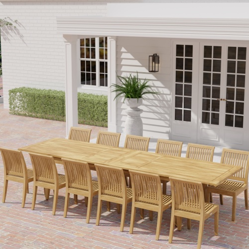 70810 Laguna 13 pc Teak Dining Set in side profile with optional umbrella and 2 potted plants on pillars with door in center and house in the background