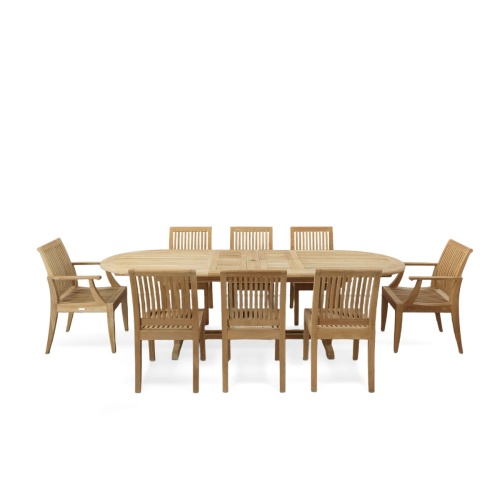 70926 Laguna Montserrat 9 piece Dining Set of Montserrat Oval Teak Table and 2 Laguna Dining Armchairs and 6 Laguna Side Chairs in angled end view on patio with ocean in background
