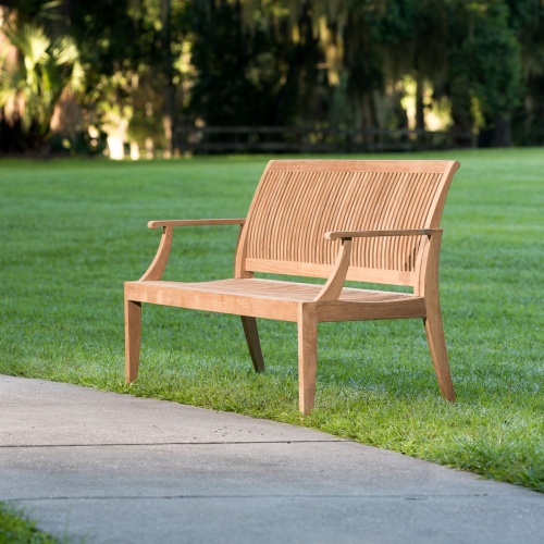 13812 Laguna 5 foot long Teak Bench on grass field with concrete low wall in background