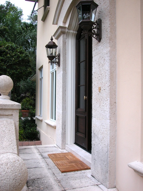 18411 parquet teak tiles with two tiles together in front of a doorway on concrete step trees in background