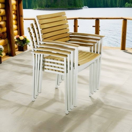 22007ST Vogue Dining Chair in side angled view stacked 4 high on outdoor deck with a lakeview in background
