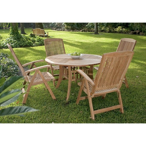 70045 Hyatt Recliner 5 piece round teak Dining Set of 4 teak reclining armchairs and a round 48 inch diameter dining table on grass field with background of trees in distance