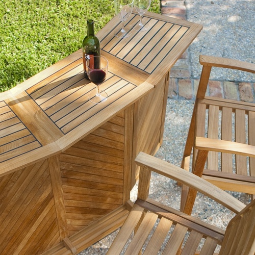  70072 somerset teak bar and stool set opened with wine bottle and three wine glasses on concrete patio aerial angle view with grass and stone walkway in background  