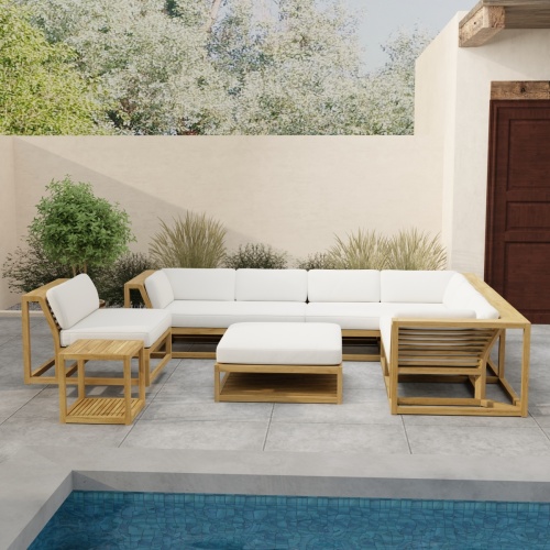 70273 Maya 6pc Sectional Set in front view on patio overlooking a pool with landscaping and potted plants against privacy wall and a door of house in background 
