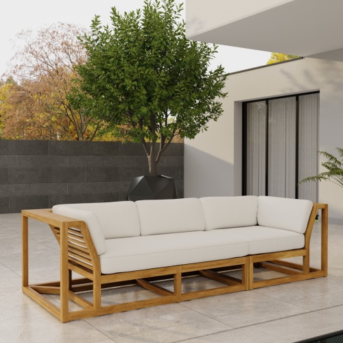 70277 Maya Deep Seating Sofa of Maya Right Side Sofa Sectional and Corner Sectional in angled front view on patio facing a pool with fence and trees in background