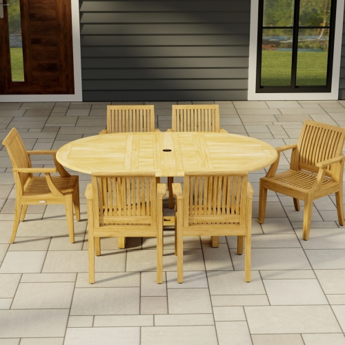 70306 Martinique 7 pc Teak Dining Set of Martinique Teak Oval Extending Dining Table and 6 Laguna DIning Chairs side view on stone patio with house window and door in background