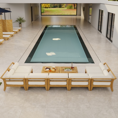 70348 Aman Dais 9 pc Lounge Set with bolsters and cushions aerial front view facing a pool  with privacy wall and trees in background