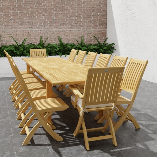 70351 Laguna Barbuda 15 pc Dining Set of 14 dining armchair and rectangular 11 foot extendable dining table angled end view on patio with wall and plants in background