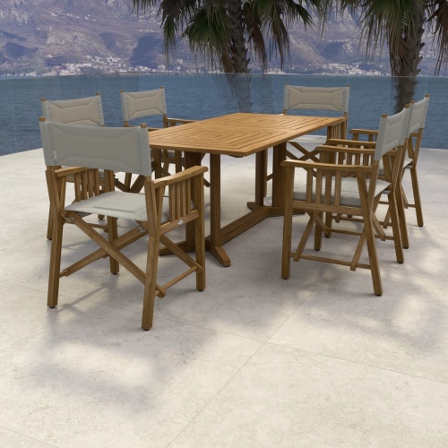 70360 Pyramid Director 7 piece teak Dining Set of 6 teak Director Chairs and Pyramid Teak Dining Table aerial view on stone patio with palm tree and ocean in background