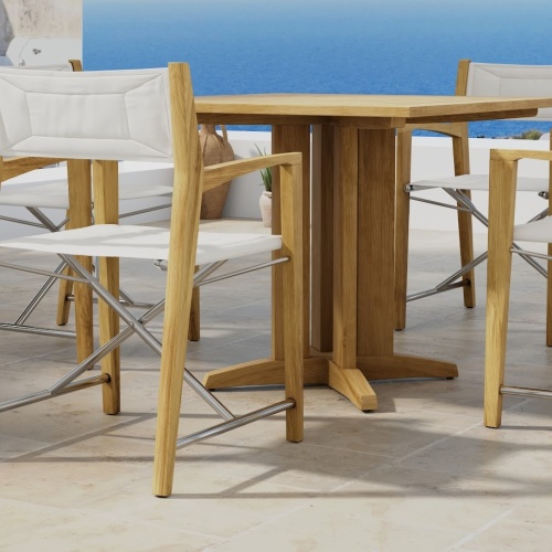 70455 Odyssey Pyramid 5 piece Bistro Set of Pyramid 36 inch Square Table and 4 Odyssey Folding Chairs on outdoor terrace with houses and the ocean and blue sky in the background