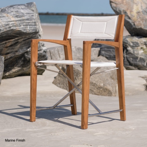 70456 Odyssey Buckingham director chair facing left on sandy beach by boulders with beach ocean and blue sky in background