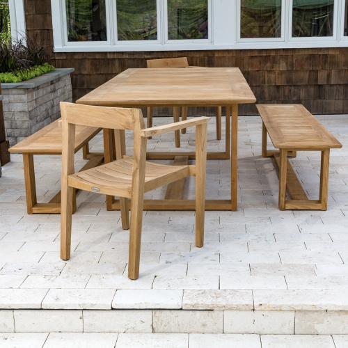 70496 Horizon 5 pc Table & Bench Set in end view on outdoor paver patio with plants and window background