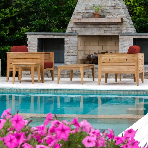 70507 Craftsman 5 piece teak Dining Set of 2 lounge chairs with cushions and 2 teak side tables and a teak coffee table on pool patio with pool in front and fireplace and shrubs out back