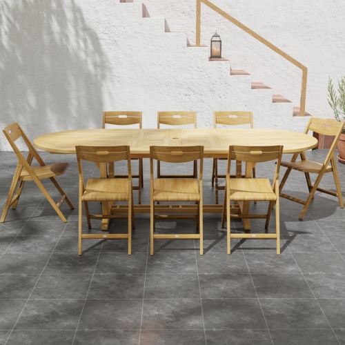 70516 Montserrat Surf 9 pc Dining Set in side view on stone patio with potted plant and stairs with lantern on step to house in background