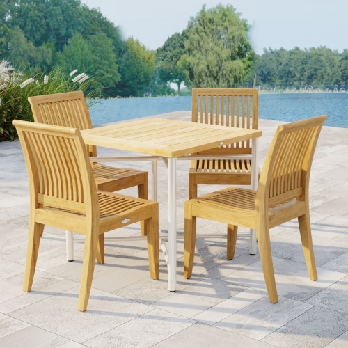 70595 Odyssey Laguna Dining Set showing Odyssey Teak and 316L Stainless Steel 32 inch Square Dining Table and 4 Laguna Side Chairs angled on patio with plants and waterview in background
