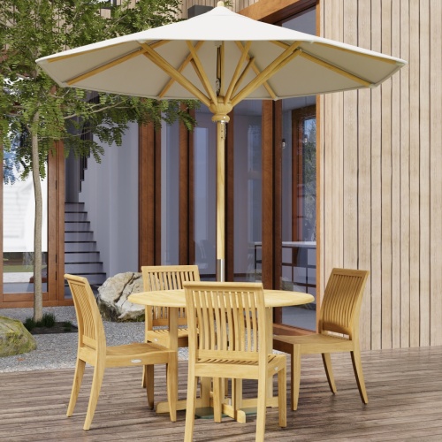 70732 Barbuda Laguna 5 pc Teak Dining Set in angled top view on patio with trees and landscape rocks and french doors and windows of house in the background