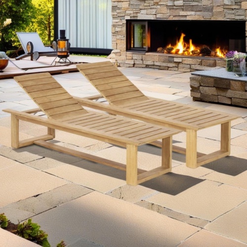 70861 Horizon teak high chaise Lounger  showing 2 side angled on paver patio with fireplace and plants and sliding glass door in background